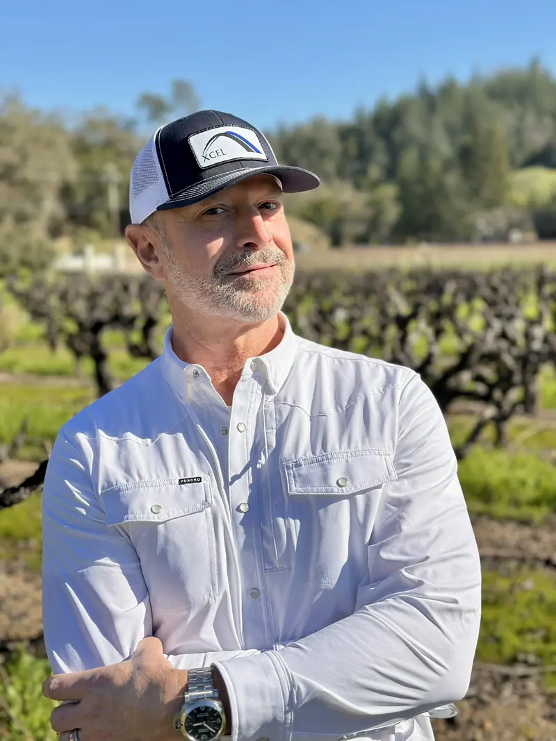 Man in baseball cap posing in vineyard